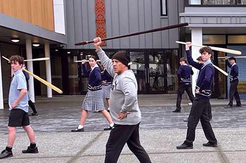 St Andrew's College students taking part in mau rākau, traditional Māori weaponry.