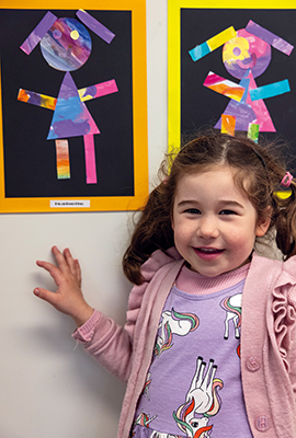 St Andrew's College Pre-school student posing with artwork at the Pre-school Art Exhibition.