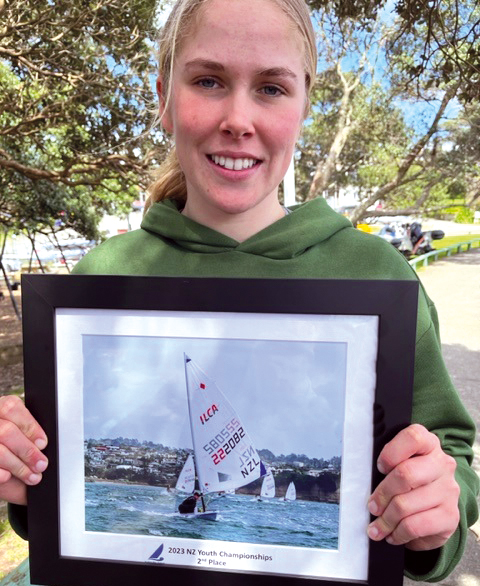 Gabriella Kenton-Smith (Y13) holding image of her sailing in competition.