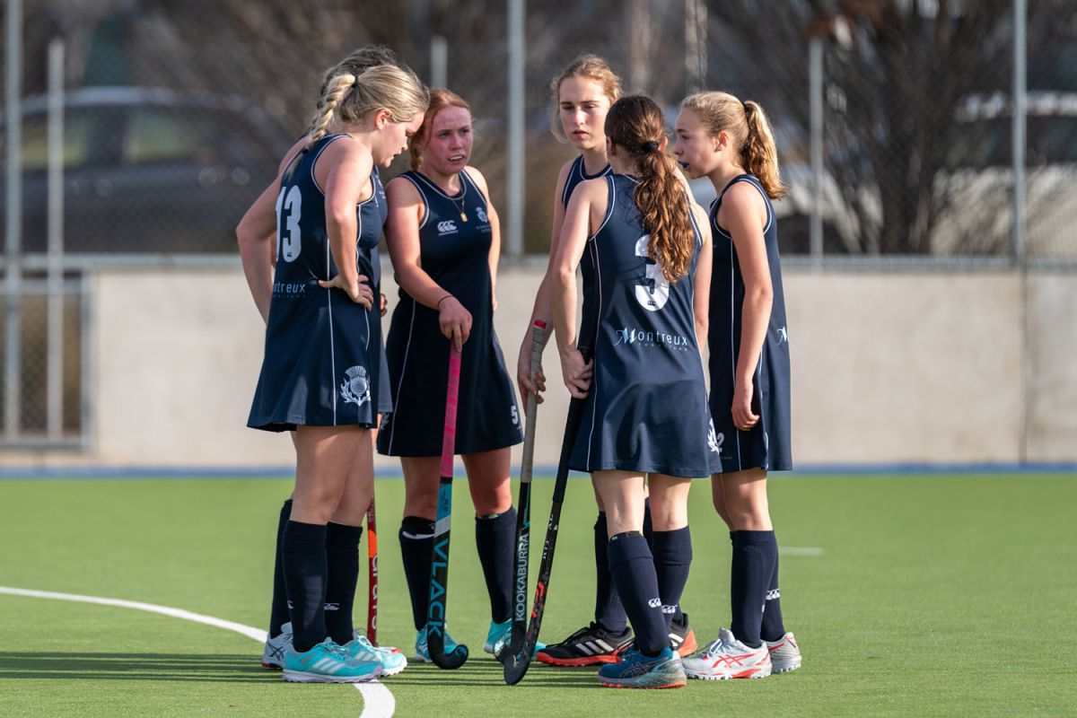 Six St Andrew's College students playing hockey.