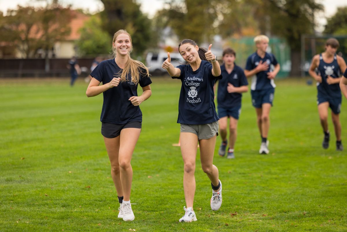 St Andrew's College students running and smiling to the camera.