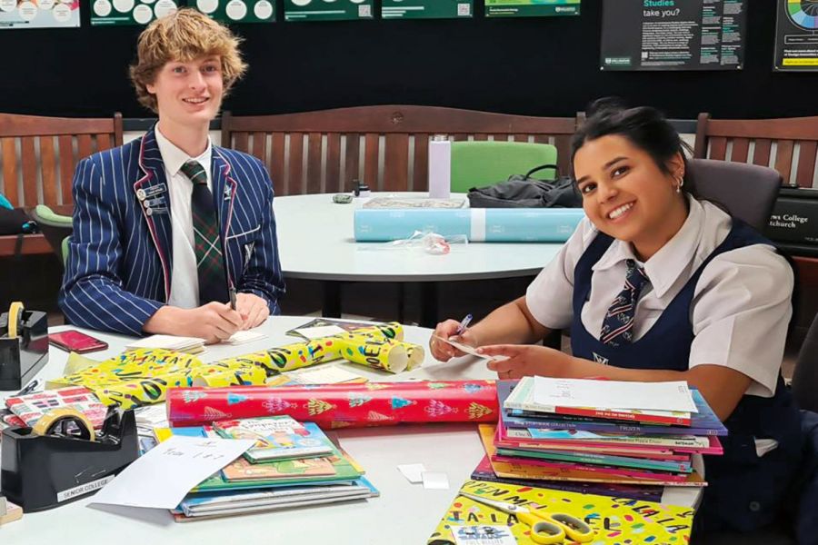 St Andrew's College students Luke Wylie and Radha Vallabh wrapping books to donate to charity.