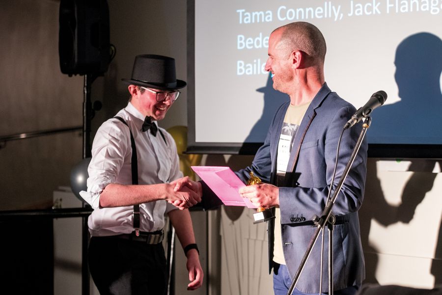 St Andrew's College student shaking the hand of the Head of Drama and Dance as he accepts an award at Film Fest.