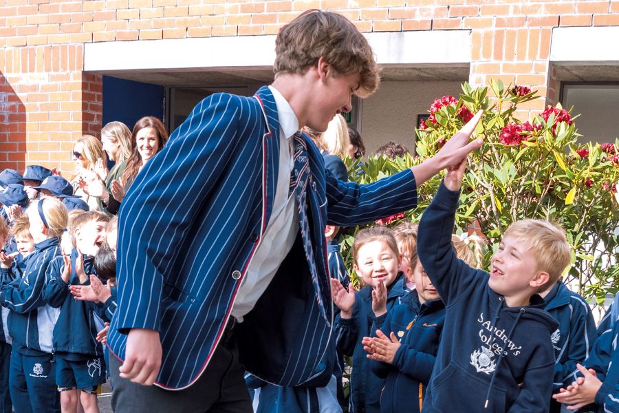 Year 13 student and Preparatory School student doing a high-five.