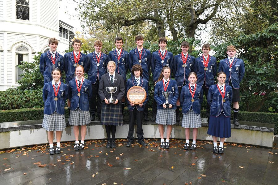 St Andrew's College students posing with their rowing medals and trophies.