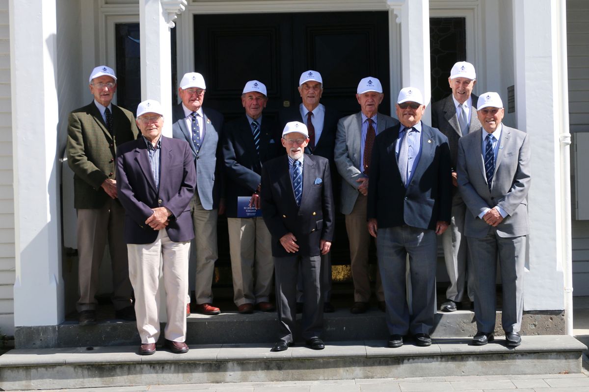 Old Collegians wearing caps gathered outside Strowan House for 70 Years On