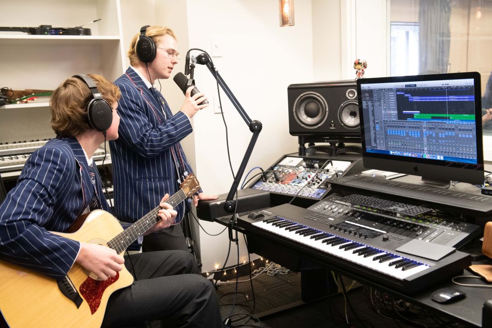 StAC music recording suite with students singing and playing guitar