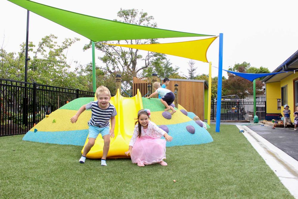 Children playing in Pre-school garden on slide