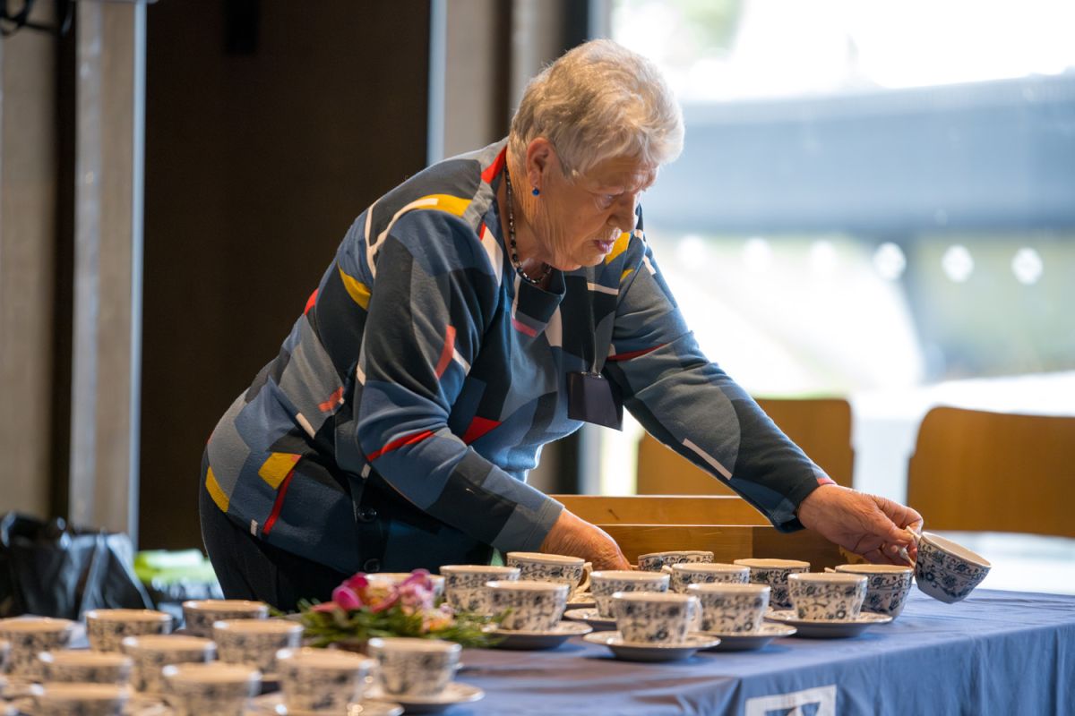 Ladies' Circle member setting up teacups at the 2024 Annual General Meeting.