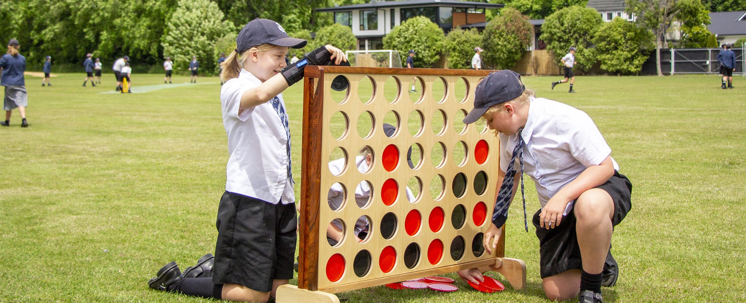 Students playing with outdoor connect four.