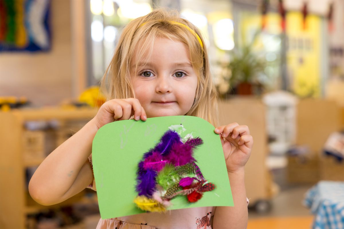 Child holding up a craft project.