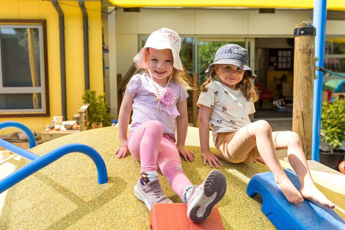 Two children playing at the playgound at St Andrew's College Pre-school.