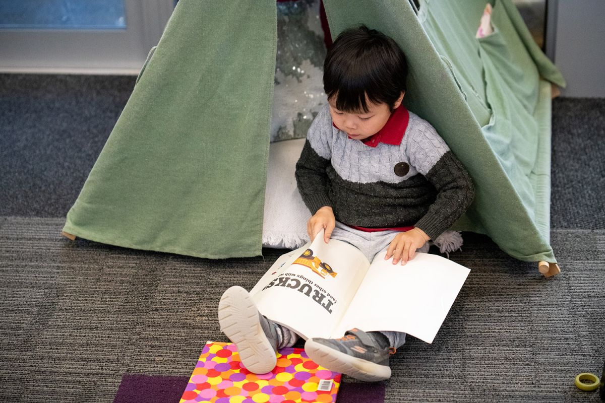 Child looking at a book at St Andrew's College Pre-school.