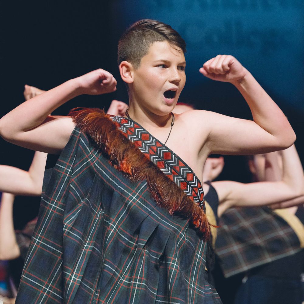 Preparatory student in traditional dress doing haka at Prizegiving
