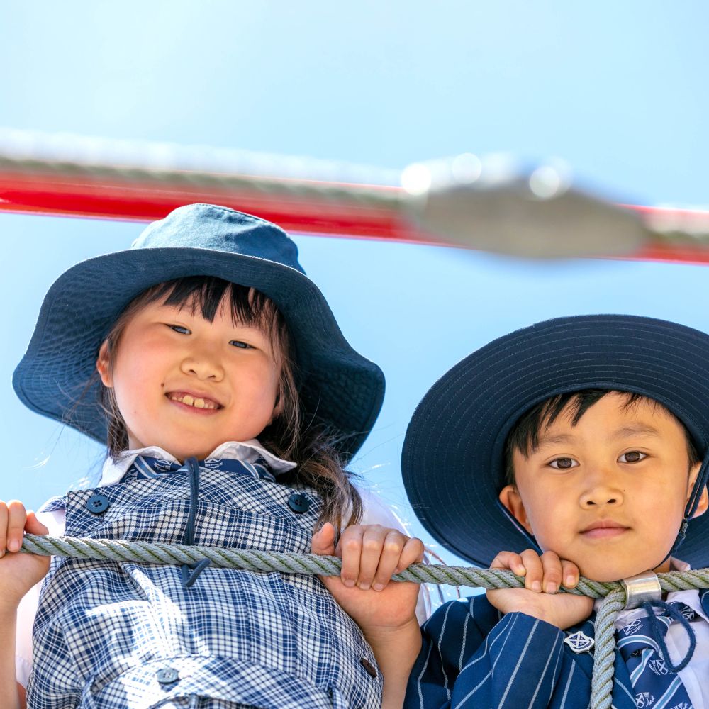 Two Preparatory students in playground wearing sun hats