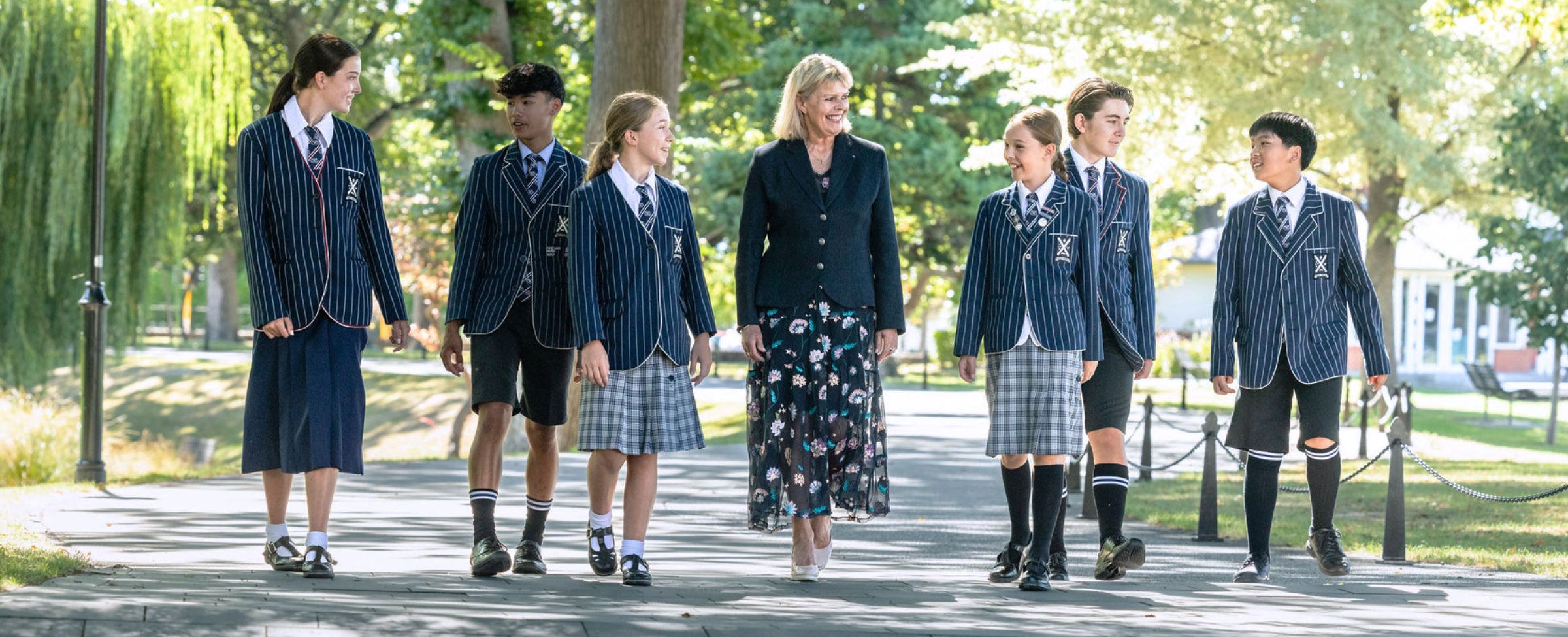 Students in uniform with Rector walking through campus