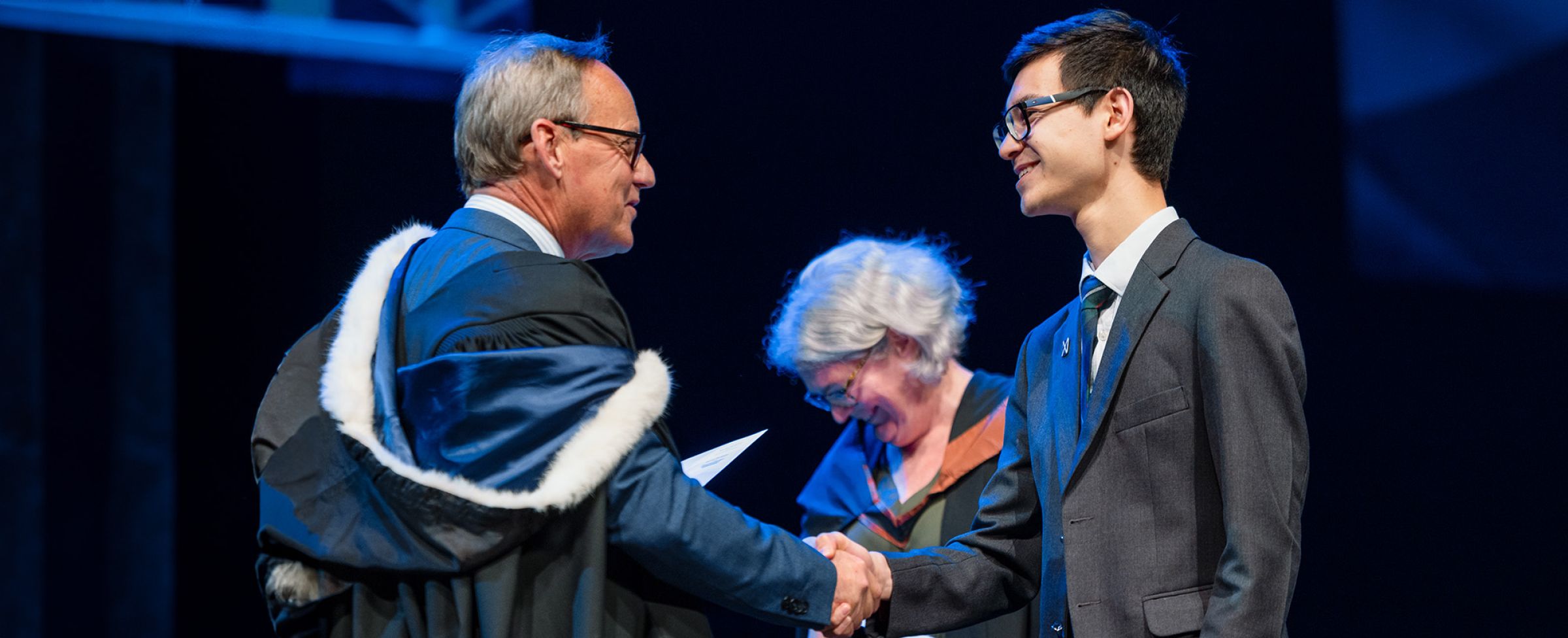 St Andrew's College Head of Secondary School giving a handshake to a student at Prizegiving.