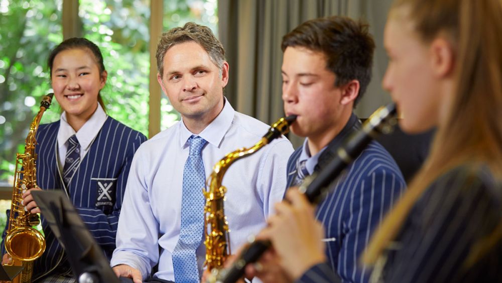 Music teacher with students playing instruments